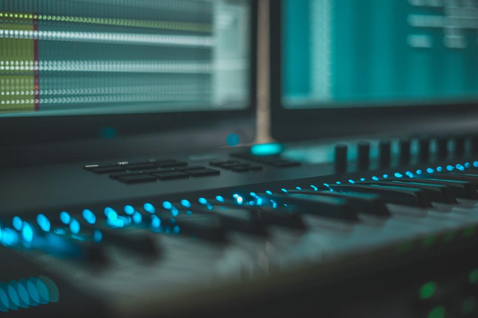 Image of a piano keyboard against the backdrop of a computer screen.