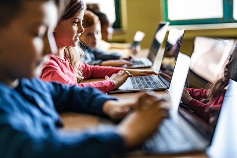 children work on computers in a classroom