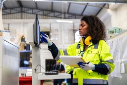 Shipping warehouse employee works on a computer