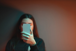 Young woman holds up phone to her face