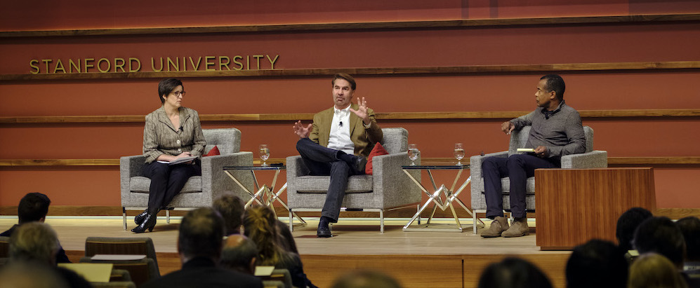 MIT economist Erik Brynjolfsson (center, along with Susan Athey and Ken Denman) called for a values-based approach to harnessing AI for shared prosperity. Photo by Ryan Zhang
