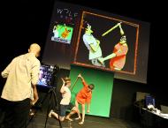 On stage, actors depict a sword-fight scene while an AI mimics their movements.