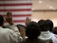 Immigrants appear at a swearing in ceremony for US citizenship.