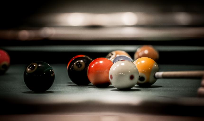 A close up of billiard balls on a pool table