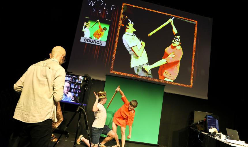 On stage, actors depict a sword-fight scene while an AI mimics their movements.