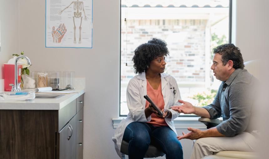 A doctor meets with a patient to discuss his prognosis. 