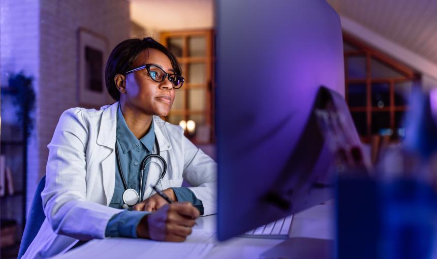 A doctor works on a computer