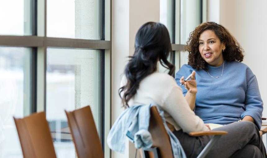 Two women seated, in deep conversation.