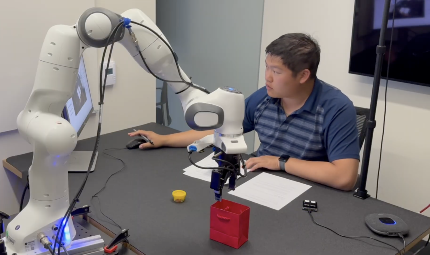 A student works with a robotic arm