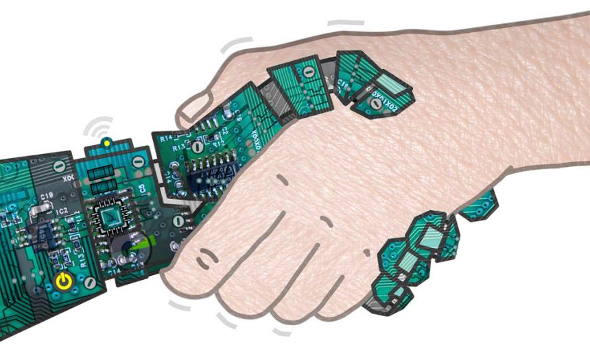 A robot hand and human hand shake.
