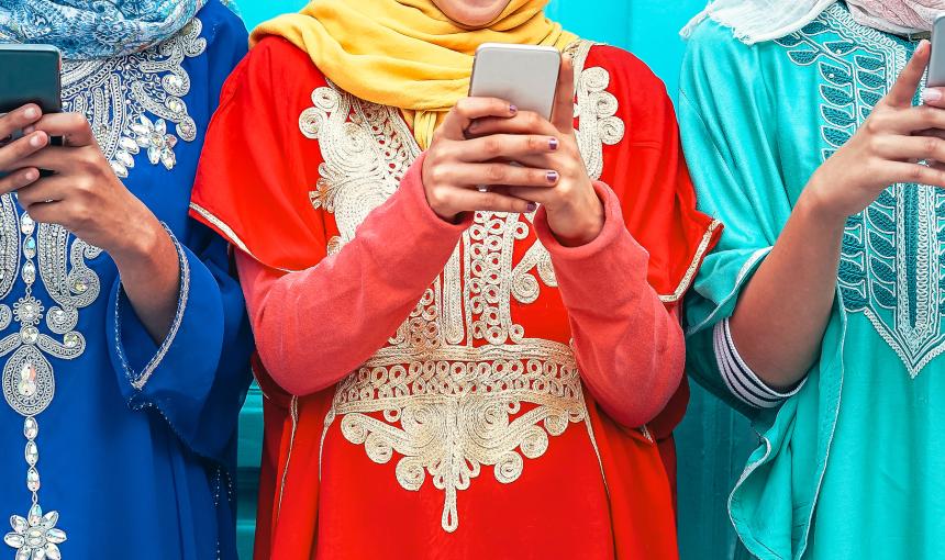 Young Muslim women using their mobile smart phones