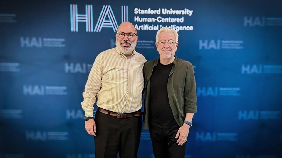 Oussama Khatib and James Landay standing in front of the HAI logo