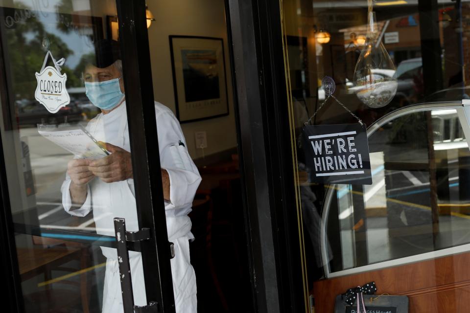 A mask-wearing worker opens a restaurant in Miami. 