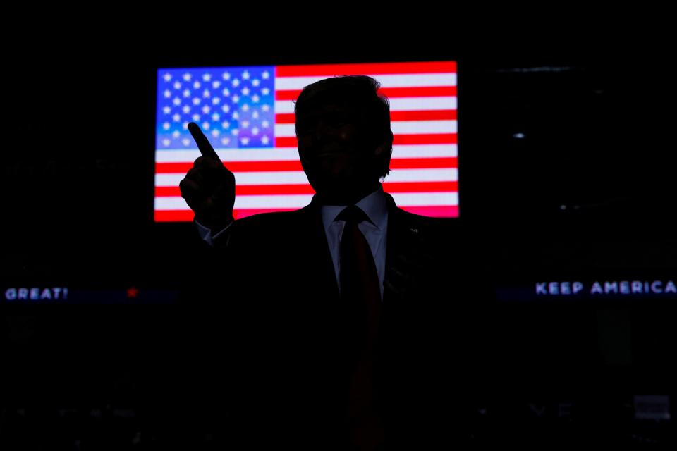 U.S. president Donald Trump against the backdrop of an American flag