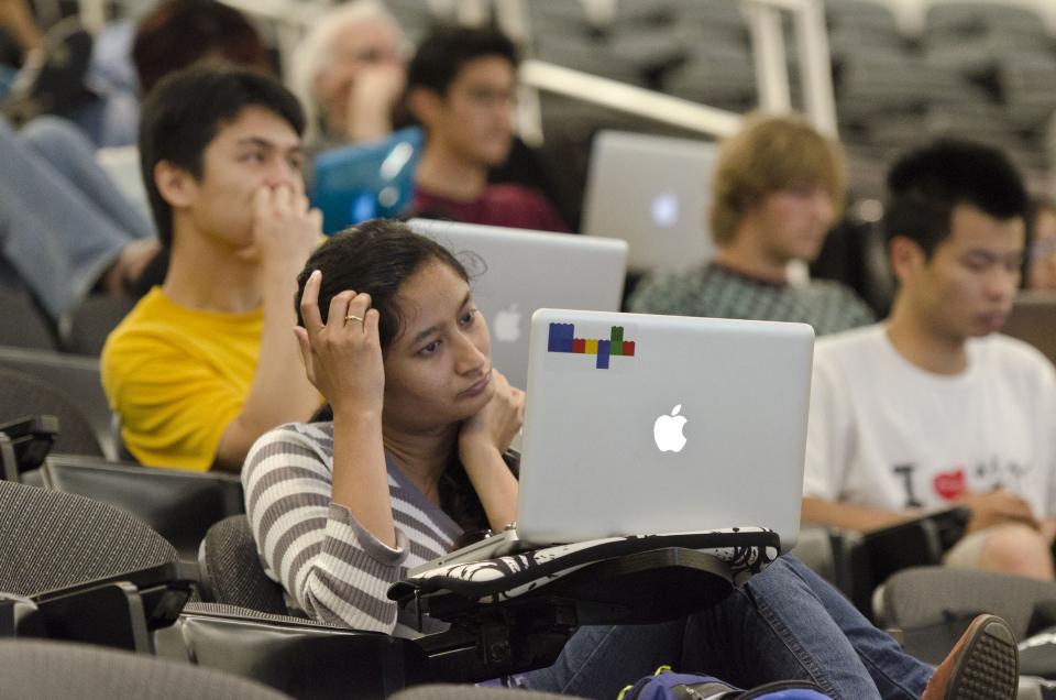 students work on computers in a lecture hall