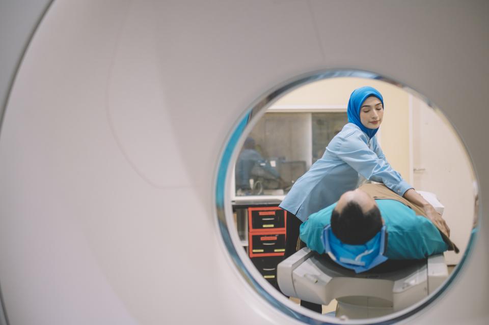 A patient is prepared for hospital CT scan by a nurse.