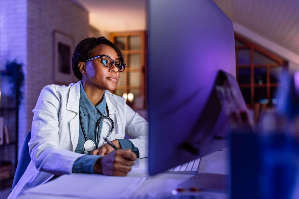 A doctor works on a computer