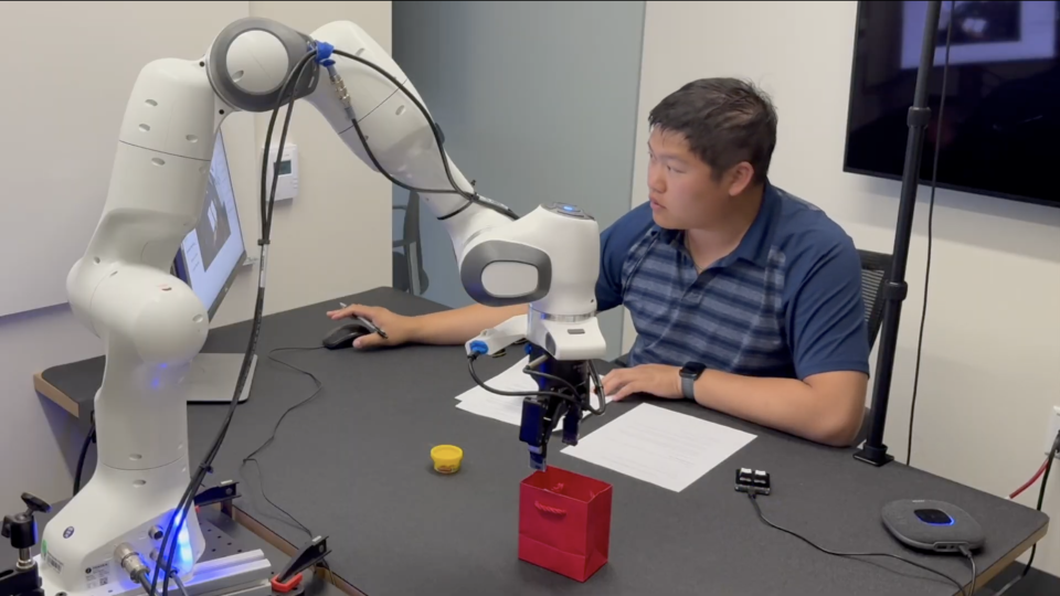 A student works with a robotic arm