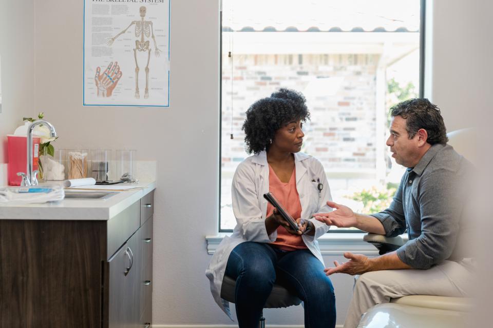 A doctor meets with a patient to discuss his prognosis. 